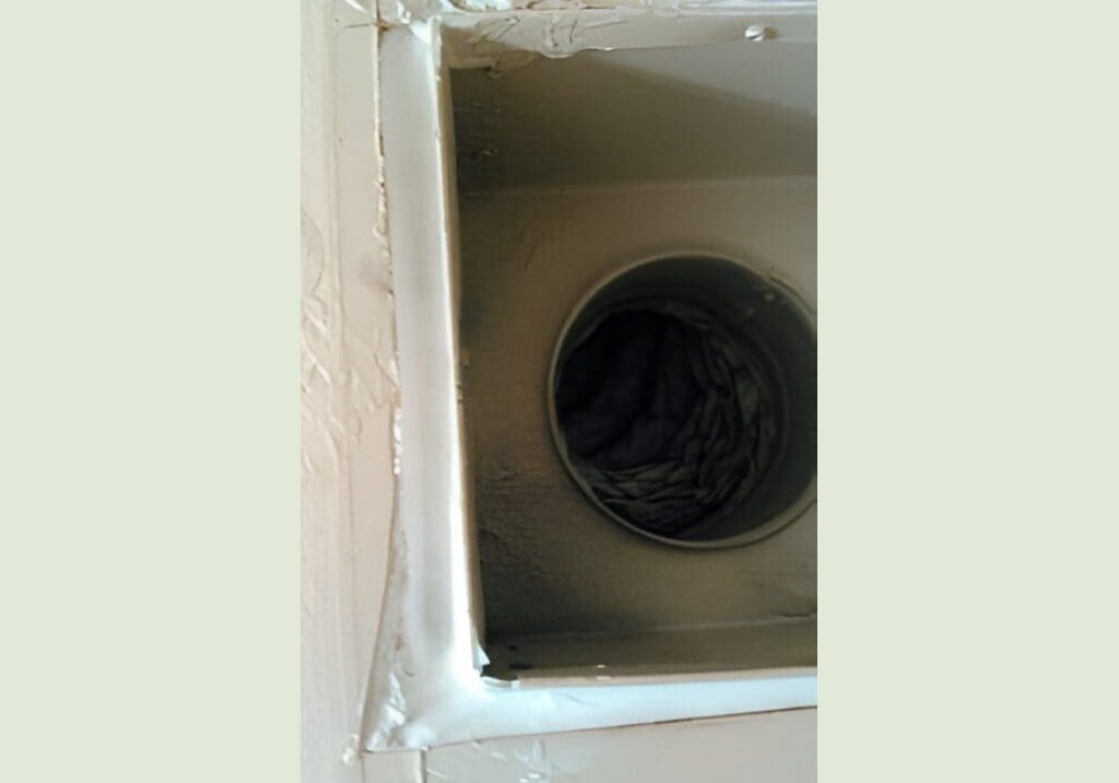 Inside view of a duct with some debris or fabric inside.