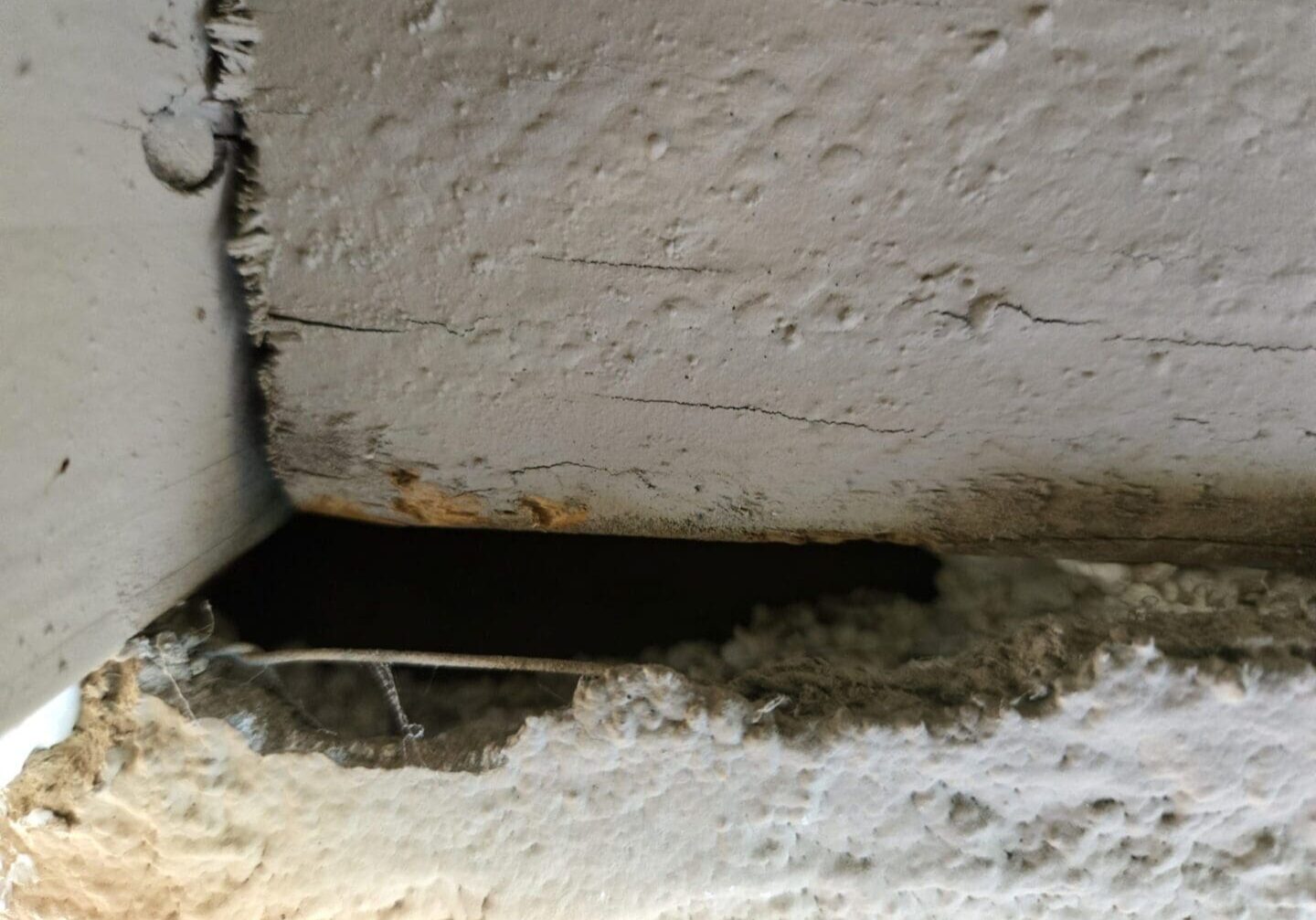 A small rectangular hole in a rough concrete wall.