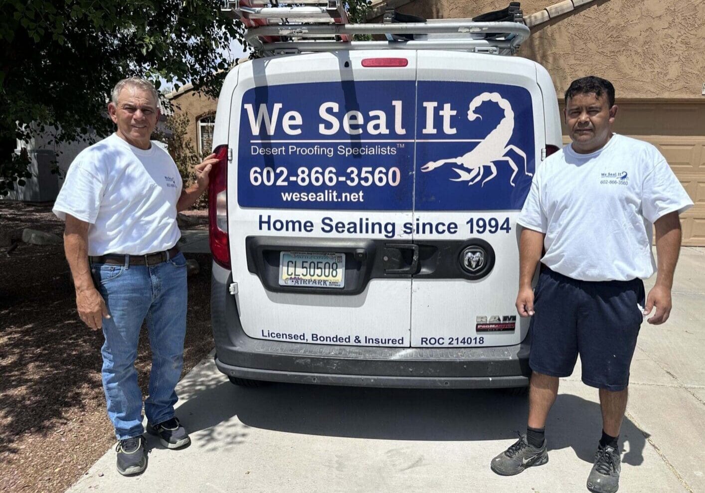 Two men stand beside a van advertising home sealing services.